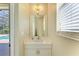 Small powder room with single sink vanity, mirror, and window with blinds at 11770 Hidden Forest Loop, Parrish, FL 34219