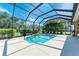 Inviting screened pool with waterfall feature, surrounded by tropical landscaping at 11770 Hidden Forest Loop, Parrish, FL 34219