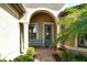 Inviting entryway with arched entry, decorative bench, and lush landscaping at 13872 Umbria St, Venice, FL 34293