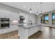 Modern kitchen with white cabinets, granite countertops, and stainless steel appliances at 9004 Artisan Way, Sarasota, FL 34240