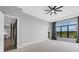 Main bedroom with ceiling fan and large windows overlooking a lake at 9004 Artisan Way, Sarasota, FL 34240