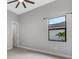 Bright bedroom with ceiling fan, large window, and neutral color palette at 9004 Artisan Way, Sarasota, FL 34240