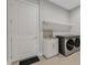 Convenient laundry room with utility sink and built-in shelving at 9004 Artisan Way, Sarasota, FL 34240