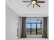 Main bedroom with ceiling fan and large windows overlooking a lake at 9004 Artisan Way, Sarasota, FL 34240