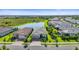 Beautiful aerial view of a home with lush landscaping and a tranquil pond nearby at 14480 Eagle Branch Dr, Nokomis, FL 34275