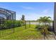 Landscaped backyard featuring a black metal fence and serene water view perfect for relaxation at 14480 Eagle Branch Dr, Nokomis, FL 34275