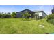 Spacious backyard with lush green grass, privacy landscaping, and a screened-in lanai at 14480 Eagle Branch Dr, Nokomis, FL 34275
