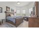 Comfortable bedroom featuring a rustic wood bed frame, natural light, and cozy furnishings at 14480 Eagle Branch Dr, Nokomis, FL 34275