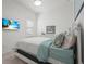 Bright bedroom featuring neutral tones, a mounted TV, and a window at 14480 Eagle Branch Dr, Nokomis, FL 34275
