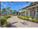 Beautiful clubhouse exterior with lush landscaping, a brick walkway, and outdoor activities like cornhole at 14480 Eagle Branch Dr, Nokomis, FL 34275