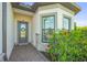 Inviting front entrance featuring a glass door with wreath, decorative sidelight, and well-maintained landscaping at 14480 Eagle Branch Dr, Nokomis, FL 34275