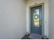 Modern front door with glass insert, decorative wreath, and stylish welcome mat at 14480 Eagle Branch Dr, Nokomis, FL 34275