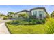 Attractive one-story home with paver driveway, two-car garage, manicured lawn, and tropical landscaping at 14480 Eagle Branch Dr, Nokomis, FL 34275