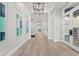 Long hallway with modern lighting fixtures, art on the walls and glass door entrances at 14480 Eagle Branch Dr, Nokomis, FL 34275