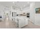 Bright kitchen boasts stainless appliances, white cabinets, and an island with bar stool seating at 14480 Eagle Branch Dr, Nokomis, FL 34275