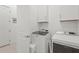 Bright laundry room featuring a new, modern, front-loading Maytag washer and dryer with white cabinets for organized storage at 14480 Eagle Branch Dr, Nokomis, FL 34275