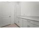 Clean laundry room featuring white cabinets and a door at 14480 Eagle Branch Dr, Nokomis, FL 34275