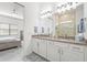Bathroom with double sinks, large mirrors, and a glass-enclosed shower, adjacent to the main bedroom at 14480 Eagle Branch Dr, Nokomis, FL 34275