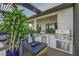 Well-equipped outdoor kitchen featuring a built-in grill, bar seating, and ample counter space, perfect for outdoor cooking at 14480 Eagle Branch Dr, Nokomis, FL 34275