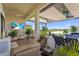 Luxurious covered patio with comfortable seating, outdoor television, and serene lake views, perfect for relaxation at 14480 Eagle Branch Dr, Nokomis, FL 34275