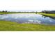 Scenic view of a serene pond surrounded by lush green grass, creating a peaceful ambiance at 14480 Eagle Branch Dr, Nokomis, FL 34275