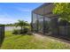 Relaxing screened patio with elegant black trim, lush landscaping, and a tranquil pond view at 14480 Eagle Branch Dr, Nokomis, FL 34275