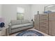 Bright sitting room featuring a gray sofa, dresser, and area rug at 14480 Eagle Branch Dr, Nokomis, FL 34275