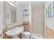 Bathroom features a glass shower, pedestal sink, and coastal decor at 3007 Avenue F # 1, Holmes Beach, FL 34217