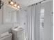 Clean bathroom with white tile, a shower, and a well-lit vanity mirror at 3007 Avenue F # 1, Holmes Beach, FL 34217
