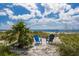 Inviting beach scene with two colorful Adirondack chairs nestled in the sand, offering a peaceful spot by the ocean at 3007 Avenue F # 1, Holmes Beach, FL 34217