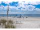 Picturesque beach view featuring a sunshade and chairs, showcasing a tranquil spot for relaxation by the water at 3007 Avenue F # 1, Holmes Beach, FL 34217
