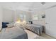 This bedroom has two twin beds, decorative pillows, a ceiling fan, and white wood paneled walls at 3007 Avenue F # 1, Holmes Beach, FL 34217