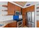 Modern kitchen with stainless appliances, wood cabinets, and granite counters at 3007 Avenue F # 1, Holmes Beach, FL 34217