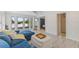 Inviting living room with white plank walls, doors to the outside deck, and comfortable seating area with plush blue couch at 3007 Avenue F # 1, Holmes Beach, FL 34217