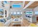 Bright living room with high ceiling, hardwood floors, ocean views, and access to the beachside deck at 3007 Avenue F # 1, Holmes Beach, FL 34217