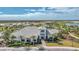 Aerial view of a grand, light-colored building with lush landscaping, golf course views, and beautiful community at 3118 Tramonto Ct, Bradenton, FL 34211