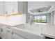 Bright kitchen features a farmhouse sink, white cabinets, and modern countertops, with a glimpse of the living area at 3118 Tramonto Ct, Bradenton, FL 34211