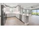 Modern kitchen with white cabinets, an island, and an open view into the living area at 3118 Tramonto Ct, Bradenton, FL 34211