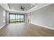 Large living room features tray ceiling, wood floors, neutral colors, and sliding glass doors with lake view at 3118 Tramonto Ct, Bradenton, FL 34211