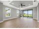 Open living room with tray ceiling, wood floors, and large sliding glass doors with view to the outdoors at 3118 Tramonto Ct, Bradenton, FL 34211