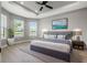 Spacious main bedroom with tray ceiling, ceiling fan, large windows overlooking lake, and decorative furnishings at 3118 Tramonto Ct, Bradenton, FL 34211