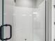 Modern walk-in shower featuring white subway tile, black trim, and speckled stone flooring at 3118 Tramonto Ct, Bradenton, FL 34211