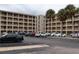 Exterior of the condominium building showing parking and palm trees at 3807 Lake Bayshore Dr # H-416, Bradenton, FL 34205