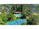 Aerial view of the condo community with a pool, clubhouse, tennis court and tropical landscaping at 3810 75Th W St # 116, Bradenton, FL 34209