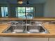 Close up of a stainless-steel double-basin sink with gooseneck faucet and tiled backsplash at 3810 75Th W St # 116, Bradenton, FL 34209