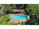 Aerial view of the community pool with lounge chairs, picnic tables, and lush landscaping at 3810 75Th W St # 116, Bradenton, FL 34209