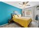 Cozy bedroom with a bright blue accent wall, plush carpet, ceiling fan, and a sun-filled window at 4224 Madeira Ct # 3309, Sarasota, FL 34233