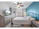 Comfortable bedroom with a queen bed, blue accent wall, ample lighting, and window views at 4224 Madeira Ct # 3309, Sarasota, FL 34233