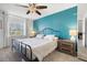 Bedroom features a queen bed with an iron headboard, blue accent wall, and ample natural light at 4224 Madeira Ct # 3309, Sarasota, FL 34233