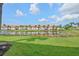 Scenic view of condos overlooking pond surrounded by manicured lawn and palm trees at 4224 Madeira Ct # 3309, Sarasota, FL 34233